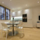 Very modern white kitchen and dining table in a studio flat in Fitzrovia